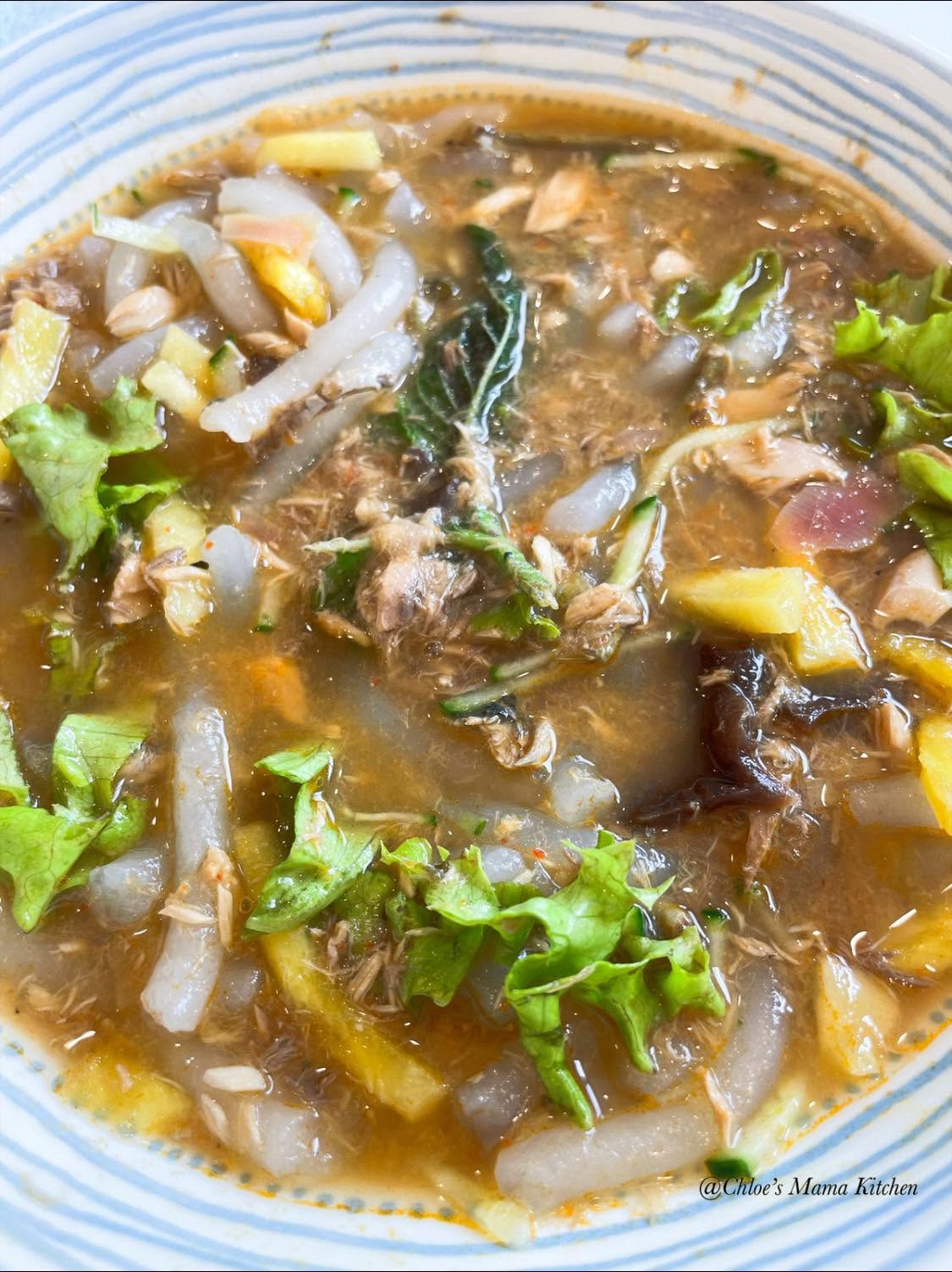 Chloe's Mama Kitchen Assam Laksa, with thick rice noodles and fish broth in a striped bowl.