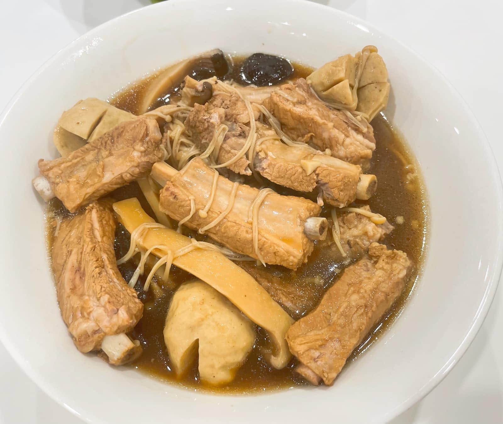 Chloe's Mama Kitchen Bak Kut Teh, with pork ribs and mushrooms in broth in a white bowl.