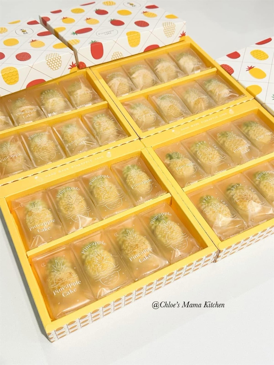 Individually wrapped pineapple tarts arranged in yellow gift boxes