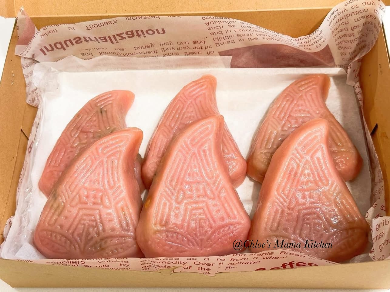 Six pink peach-shaped Teochew Png Kuih in a paper-lined box
