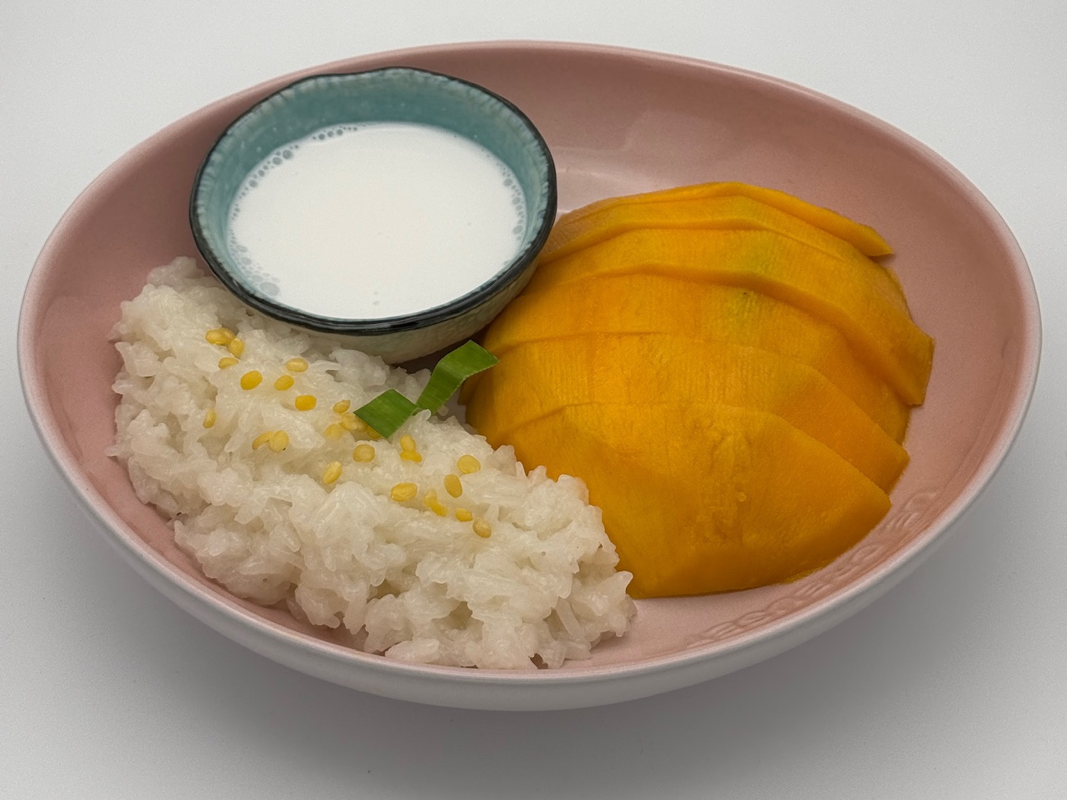 Mango sticky rice with sliced mango and coconut sauce.