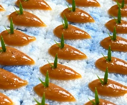 Blue glutinous rice pieces topped with caramel kaya.