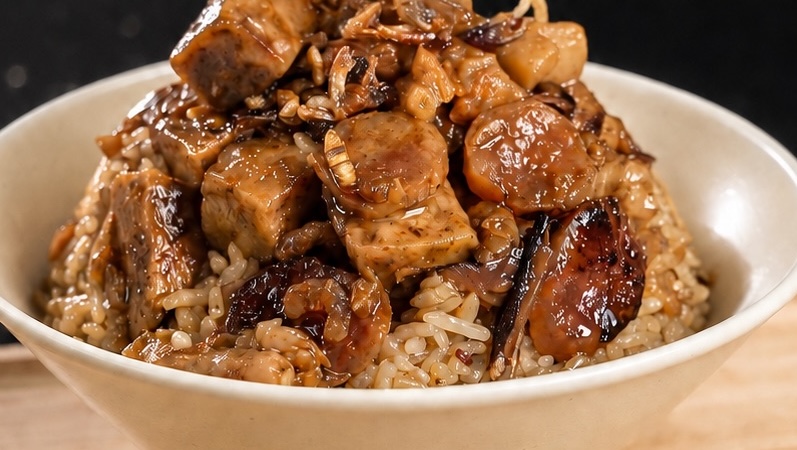 Malaysian taro rice with taro pieces, Chinese sausage and mushrooms in a bowl.